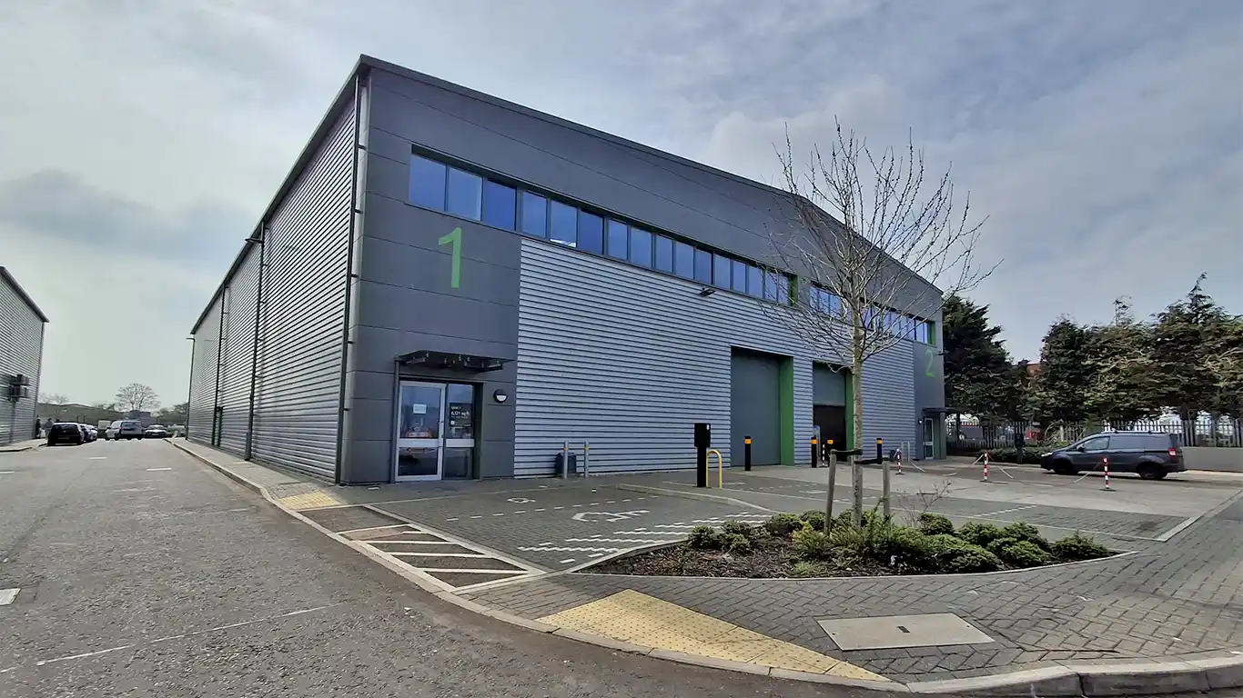 Front exterior of Unit 1 Freebournes Park warehouse with shutter door and parking.